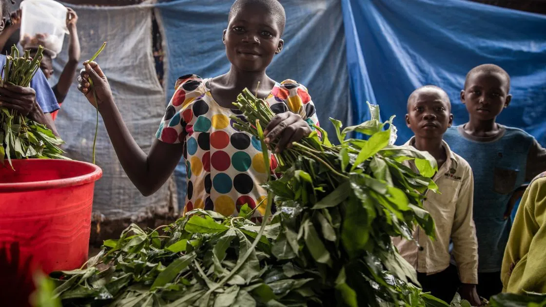 Ruth Ngoyi, 25, and her vegetables for sale at the central market of the town of Manono, Tanganyika Province. The region is beset with malnutrition and chronic poverty, but programs run by Concern Worldwide are working to alleviate this. Products grown on rural farmland as part of Concern Worldwide’s Food for Peace program are often sold at this market