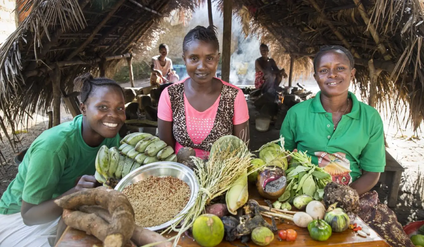 Members of the community committee in Bongay village, Sierra Leone, proudly display the range of foods they're now growing and foraging for.
