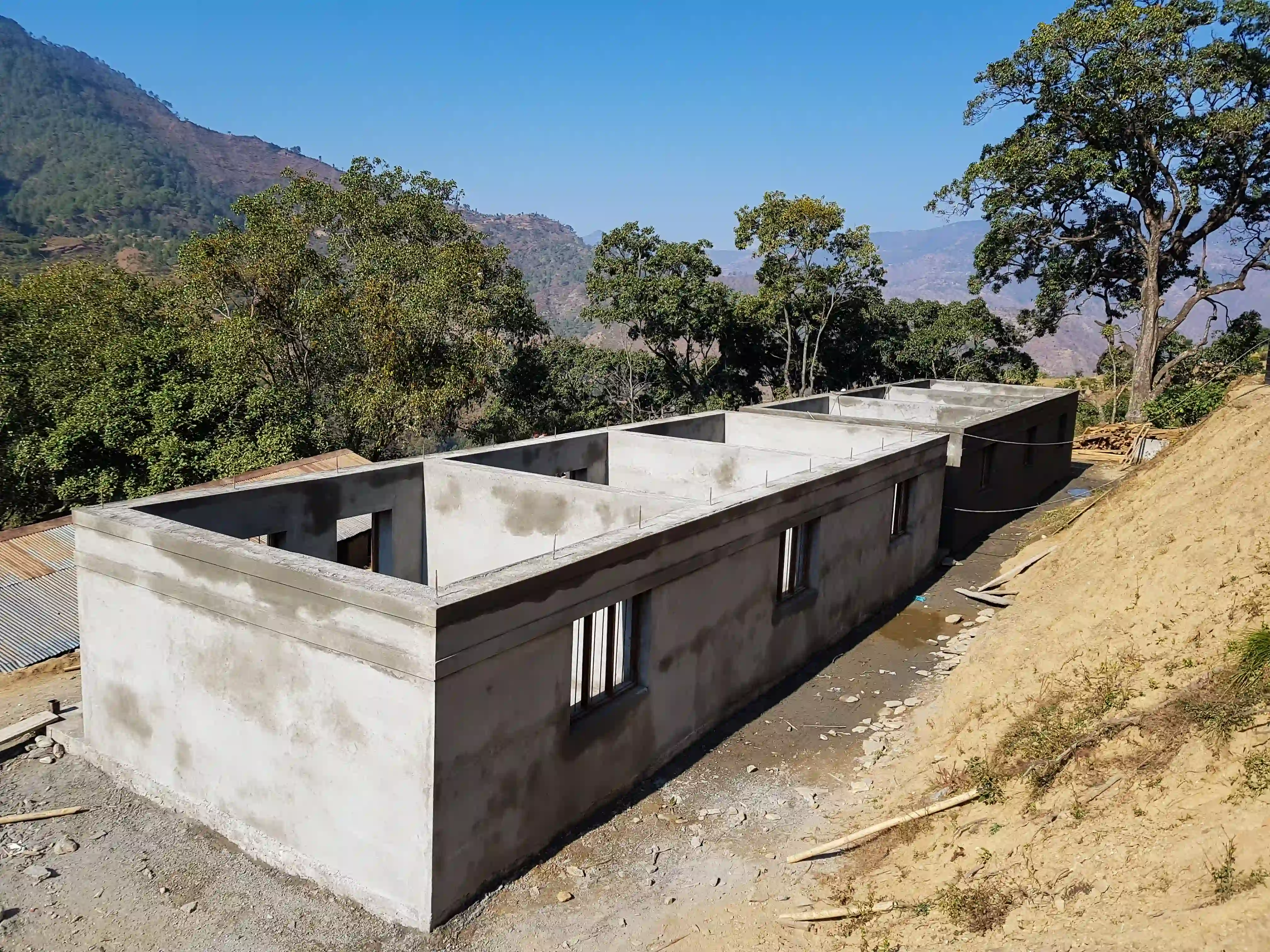 A concrete school built to roof level on hillside