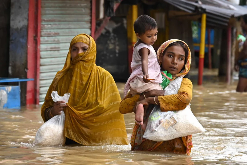People from Feni wade through the flood water on submerged roads during the 2024 Bangladesh floods. (Photo: Amit Kumar/Concern Worldwide)