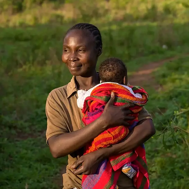 Natalie Wato (33) with her five-week-old son Sauvenator on the small plot of land the family tends near their home in Central African Republic.