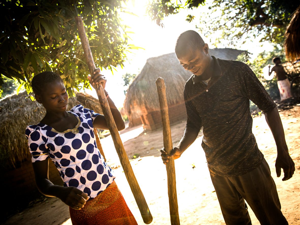 A man and woman prepare cassava flour