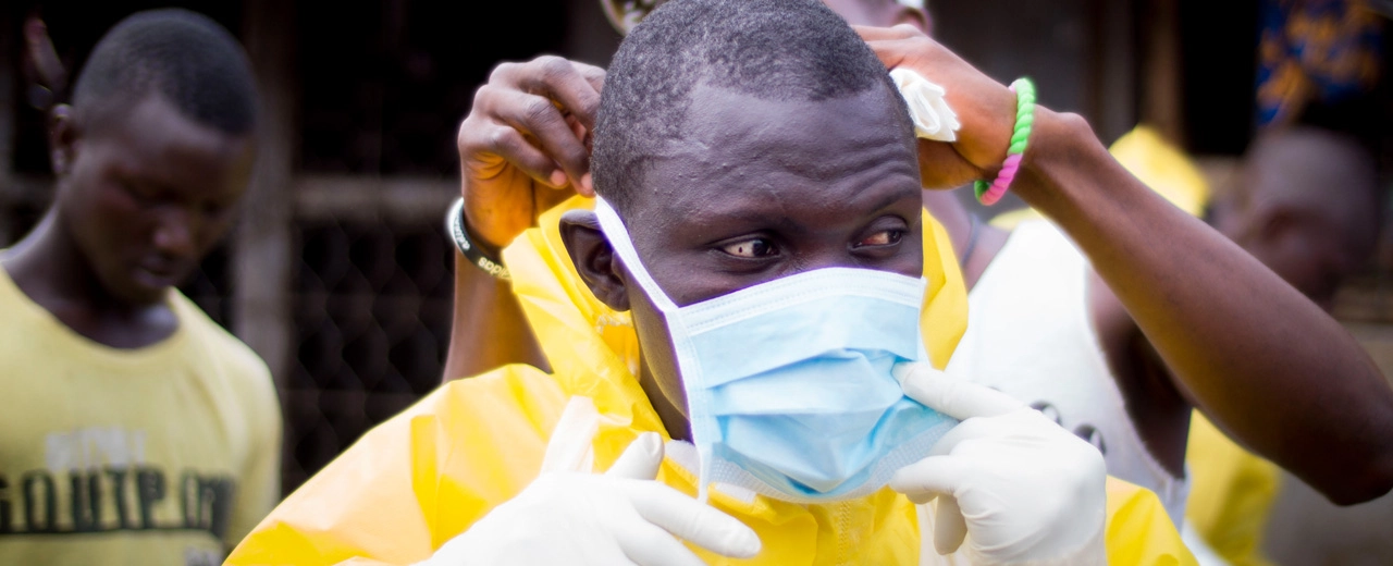 Dead body management crew member dons protective gear
