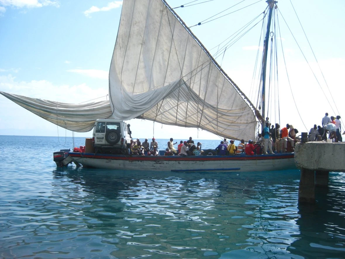 A ferry carrying people and a jeep.