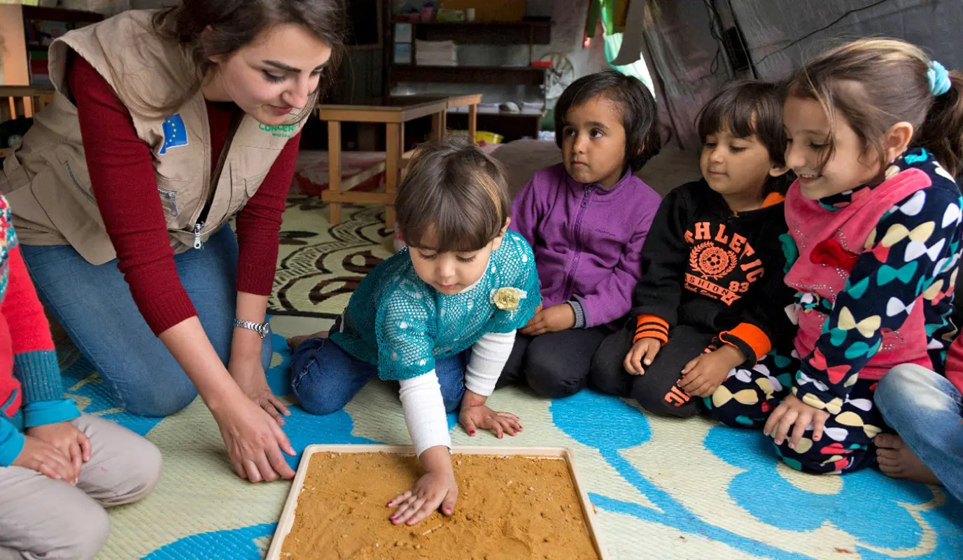 Children and concern worker in a classroom