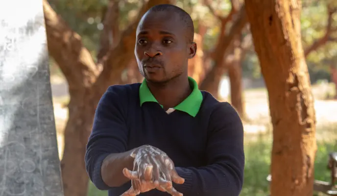 Man in Malawi leading a handwashing demonstration