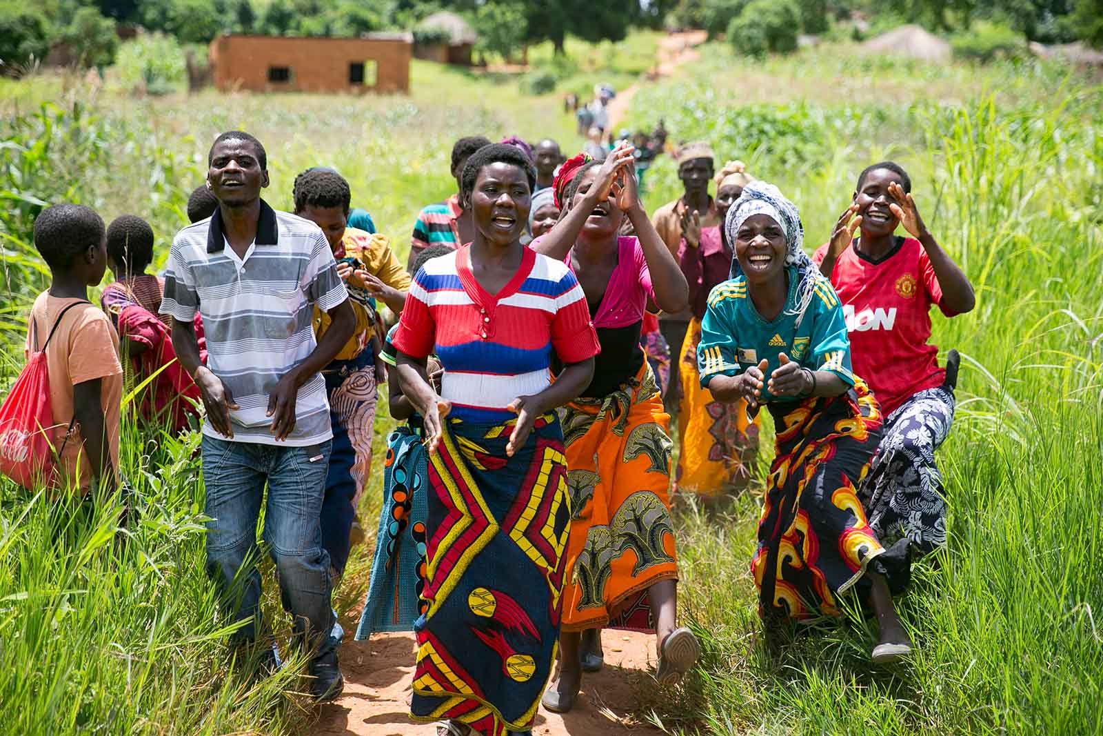 Two farmers standing in a corn field holding corn