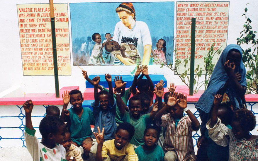 Children in Mogadishu, Somalia sit underneath a mural of the late Valerie Place.
