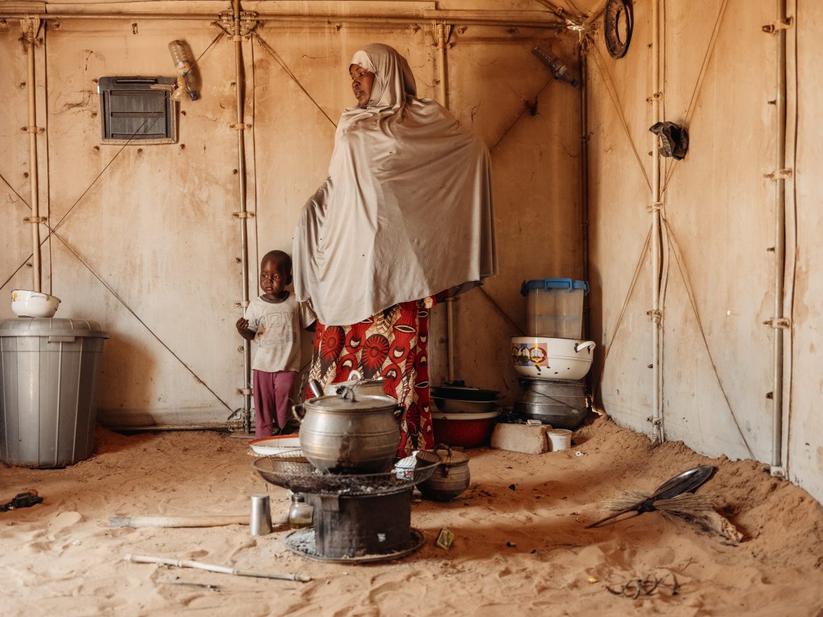 Woman standing with a small child next to a pot