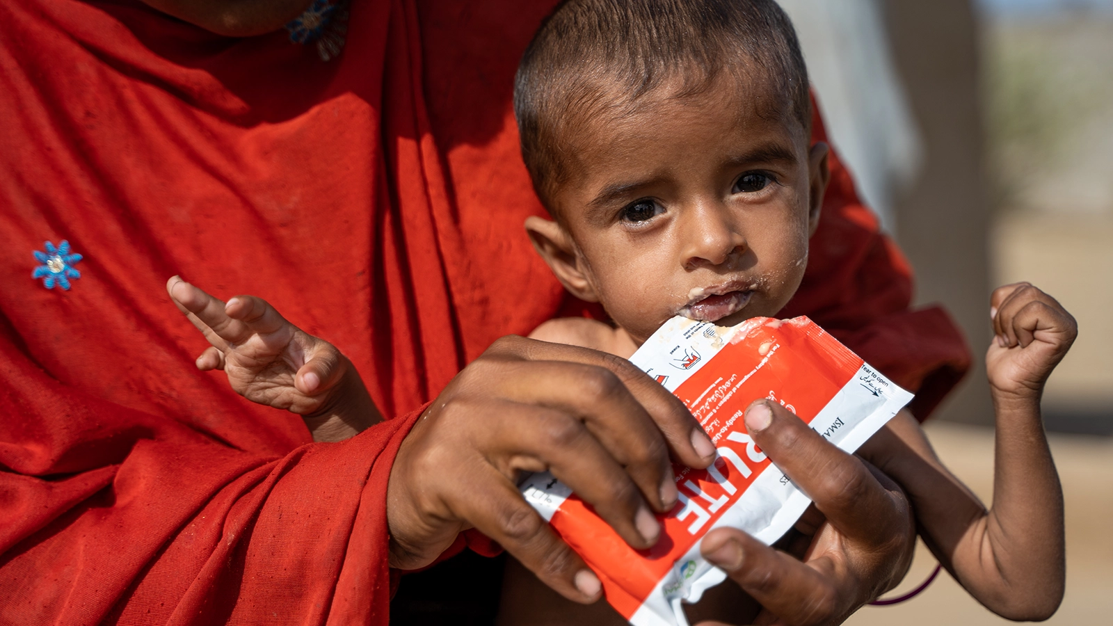 Rashida holds her severely malnourished son, Rasheed (15 months), while feeding him RUTF in Ahmed Jotorr village, Tharparkar. (Photo: Arif Shad/Ingenious Captures/Concern Worldwide)