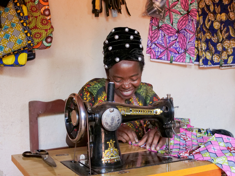 Alexia Mukashyaka at her tailoring shop in Mugombwa, Rwanda. Alexia was selected for the Graduation Programme in 2019. After investing in a sewing machine, she started up a successful tailoring business, making on average 20 outfits for women each week. She plans to expand and eventually open a hairdressing salon, and is currently receiving lessons on hair styling. Photo: Eugene Ikua/Concern Worldwide Additional Information