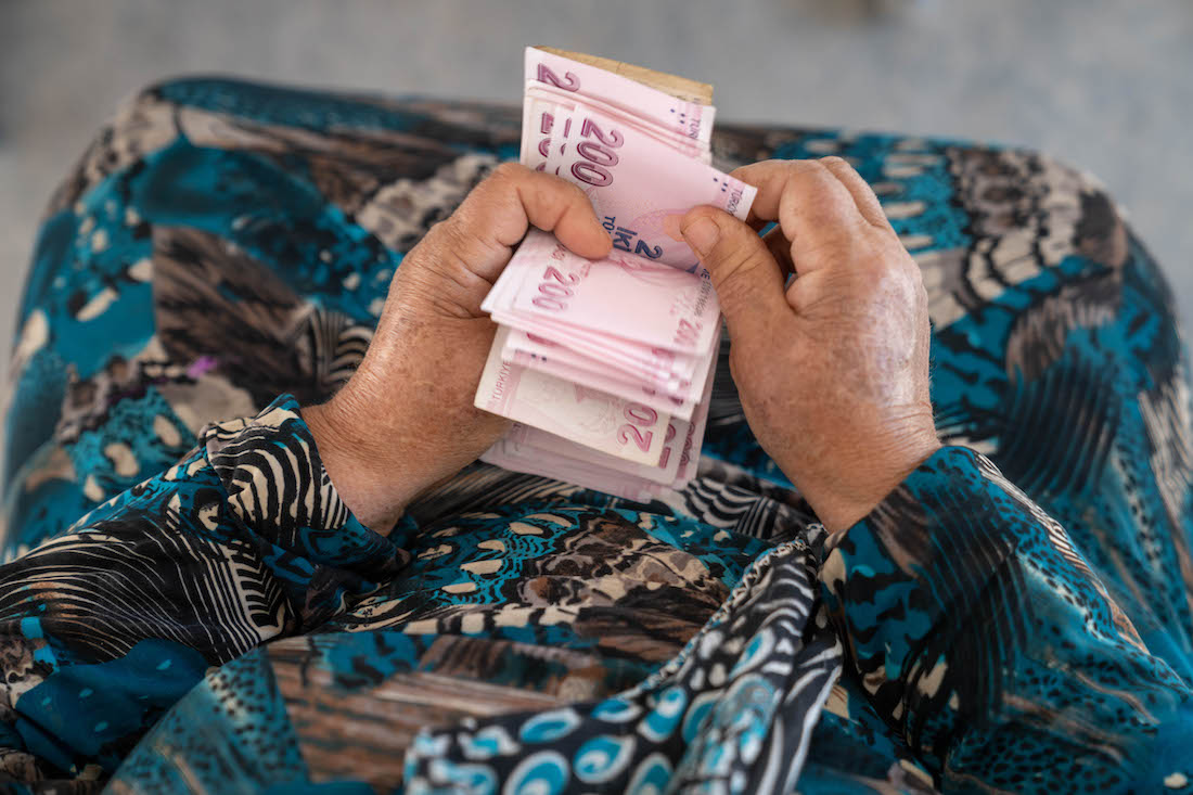 A detail shot shows Shahinaz* counting the money she has received from a cash support distribution centre at a camp in north-west Syria on 22 June 2023. As part of Concern Worldwide's response to the Syria-Turkey earthquake, cash assistance is distributed to displaced families living in camps and temporary shelters to meet their immediate basic needs. After an informational session, each household receives a cash voucher at the distribution point. (Photo: Karam Al-Masri/Arete/DEC)