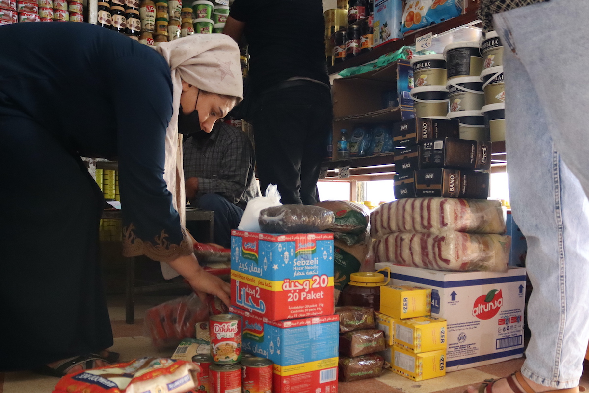 A woman chooses her food items from one of the shops where she purchases food with food vouchers in Kobani, Syria — part of an emergency food security program led by Concern Worldwide. Photo: Ahmad Al Aboud/Concern Worldwide