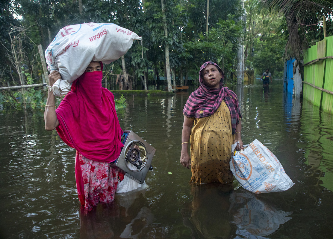 Locals make their way through a submerged road with their essential household items in Noakhali district, Bangladesh, during 2024's catastrophic floods. (Photo: Akram Hossain/Concern Worldwide)