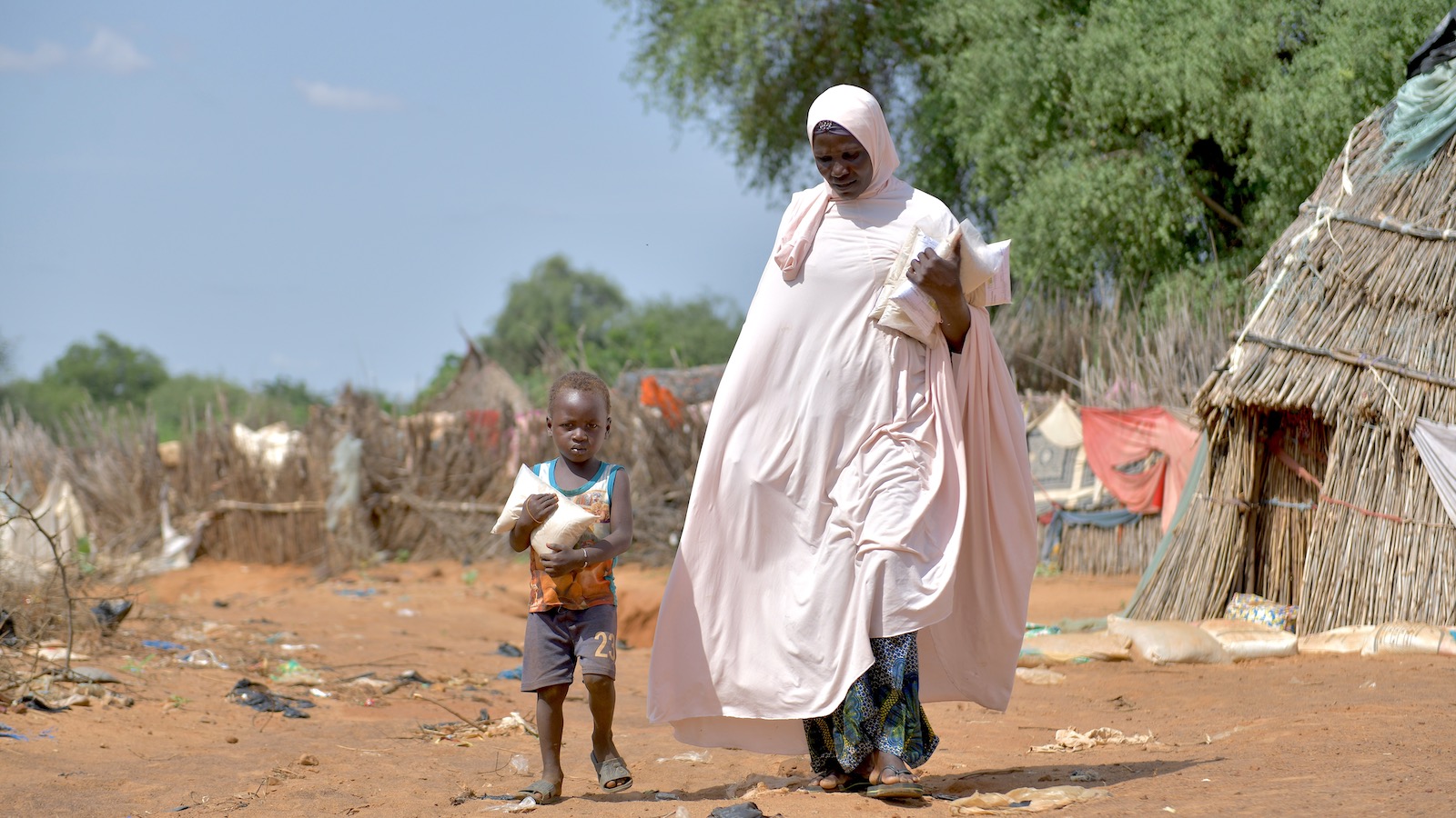 Baria Moumouni carries home packages of fortified flour with her child, distributed by Concern in Tanawara village, Niger. (Photo: Concern Worldwide)