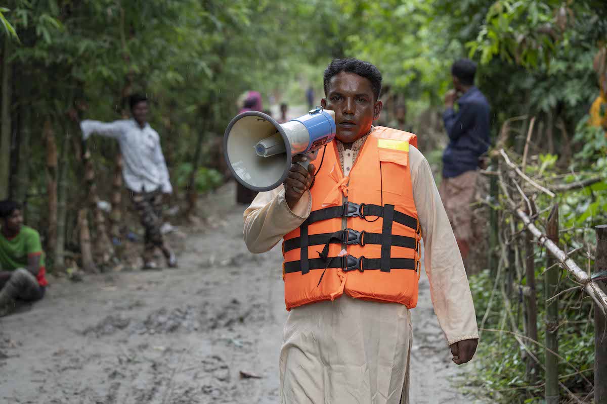 From Concern's Bangladesh Flood Resilience project, Mohammad Dukhu Mia (38, orange vest) spreads news through his community of possible incoming floods. (Photos: Saikat Mojumder/Concern Worldwide)