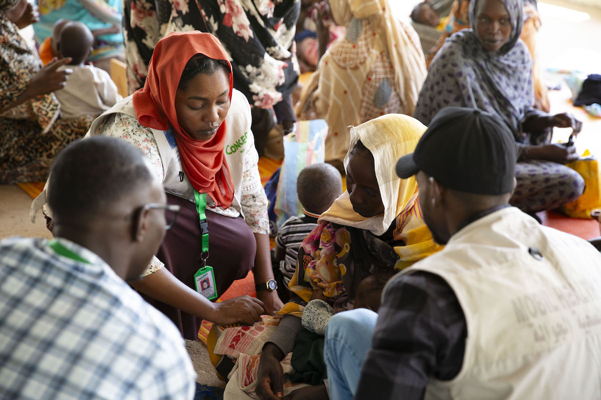 Concern Health and Nutrition Officer, Yamen Nassir, with Zarina* and baby Yaqub* at Ardamata Health Centre in West Darfur, Sudan. Yaqub* is severely acutely malnourished and has additional health complications. (Photo: Kieran McConville/Concern Worldwide)