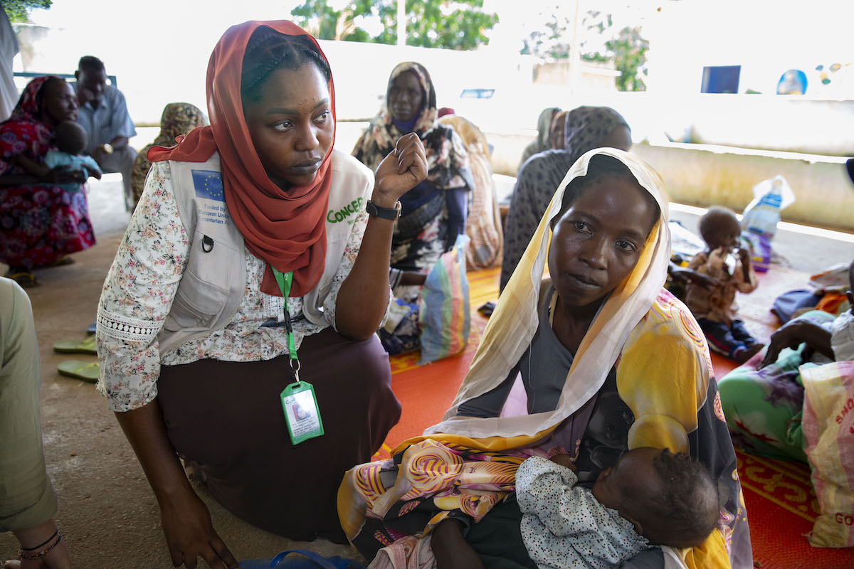 Concern Health and Nutrition Officer Yamen Nassir with Zarina* and baby Yaqub* at Ardamata Health Center in West Darfur.