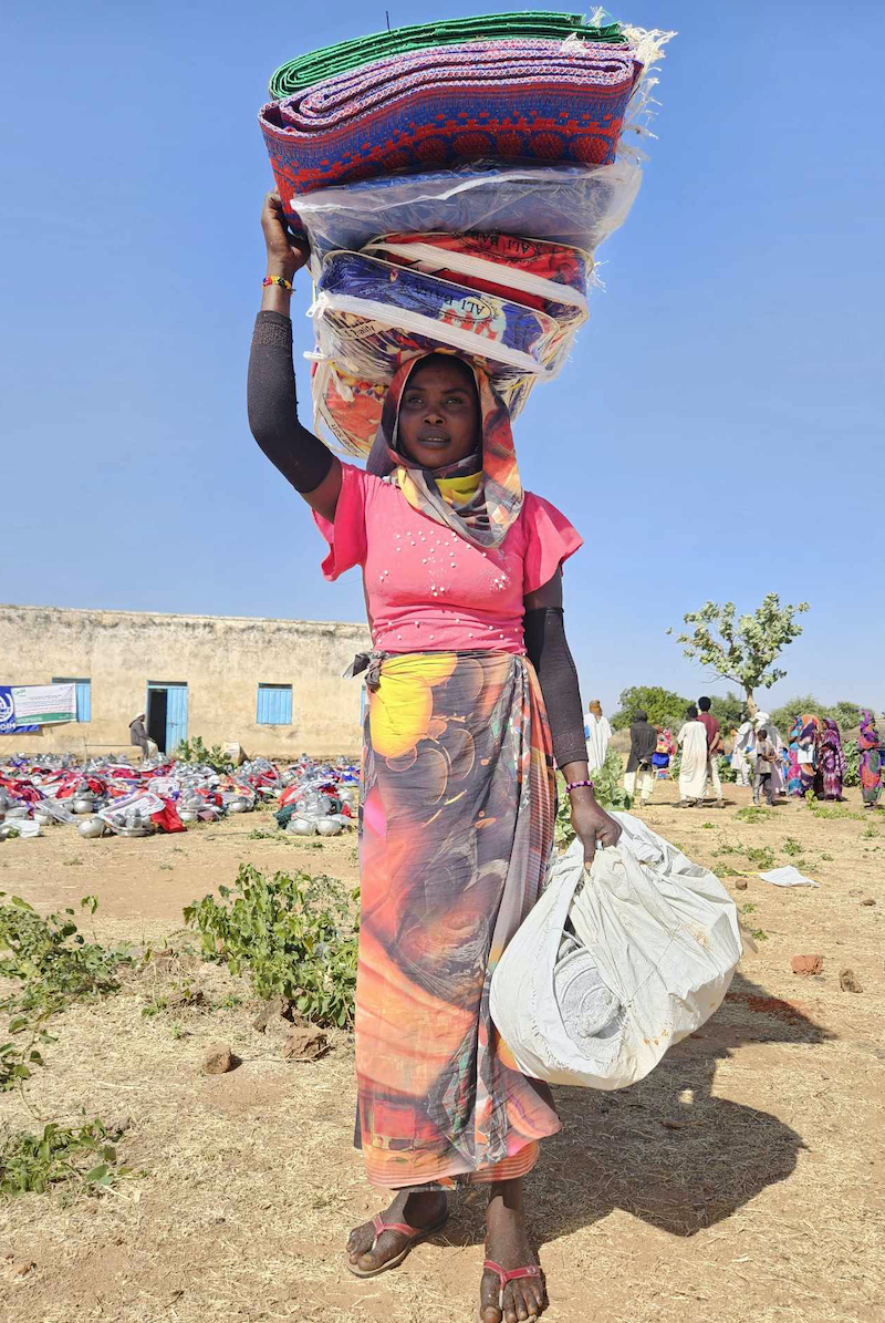 Fatima Adam Saeed (25) received a NFI kit distributed by Concern in Aishbara, 15km from Geneina. Each household received one kit containing: blanket, cooking utensils, mat, plastic sheeting, mosquito net, torch and jerry can. Photo: Nicola Brennan/Concern Worldwide