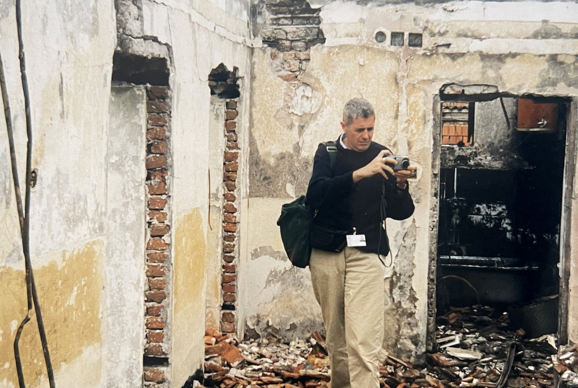 Dominic MacSorley at the remains of a house attacked during the siege of Kosovo. (Photo: Concern Worldwide)