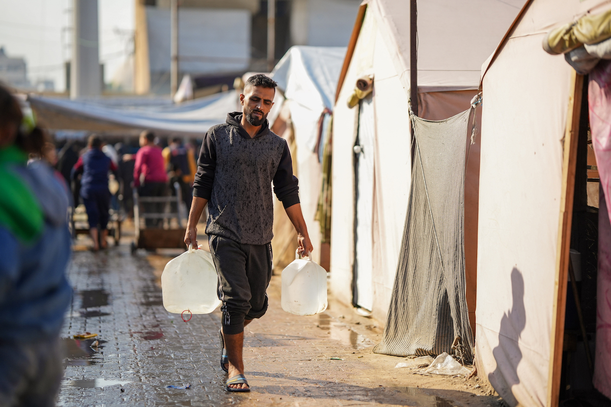 Mohammad takes containers to refill at a water distribution point in Gaza, supported by Concern and Alliance2015 partner CESVI. Photo: Abood Al Sayd/DEC