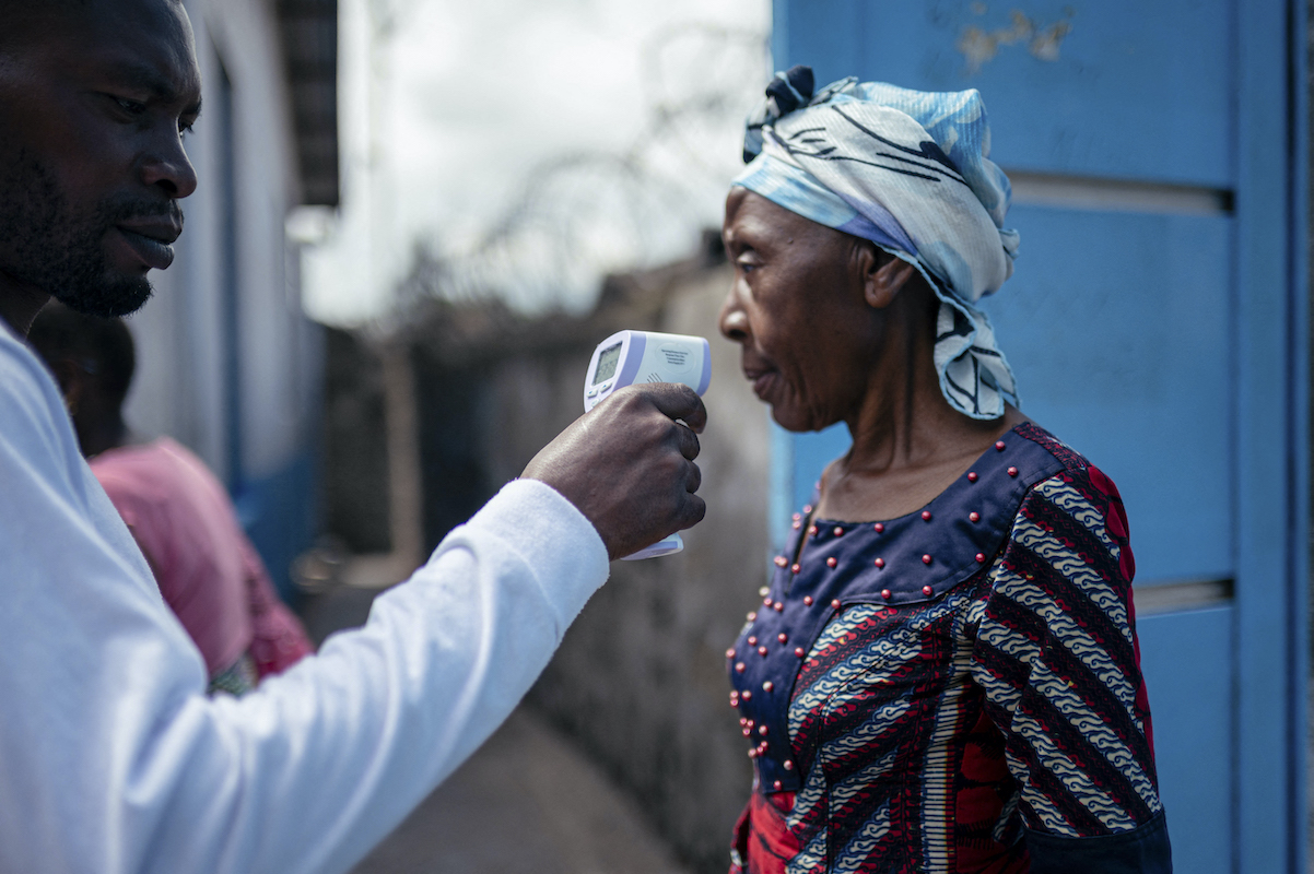 A staff member of the CBCA Virunga Hospital checks a visitor's temperature using a contactless infrared thermometer, before allowing her access to the hospital in Goma, DRC. Photo: Jospin Mwisha/AFP via Getty Images