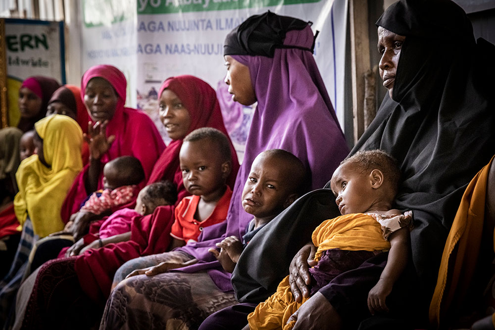 Women and babies wait in the Obosibo Halane Health Centre in Mogadishu (supported by Concern Worldwide). Somalia relies on Ukraine and Russia for nearly 90% of its grain imports, which have been interrupted due to conflict in Ukraine. The country has also faced its worst drought in 40 years, making food and nutrition key concerns. (Photo: Ed Ram/Concern Worldwide)
