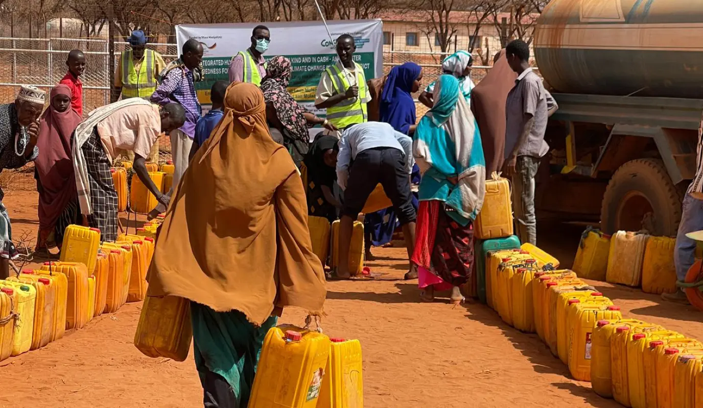 A Somali woman gathers water, trucked into the community by Concern Worldwide, in response to the droughts of 2022.