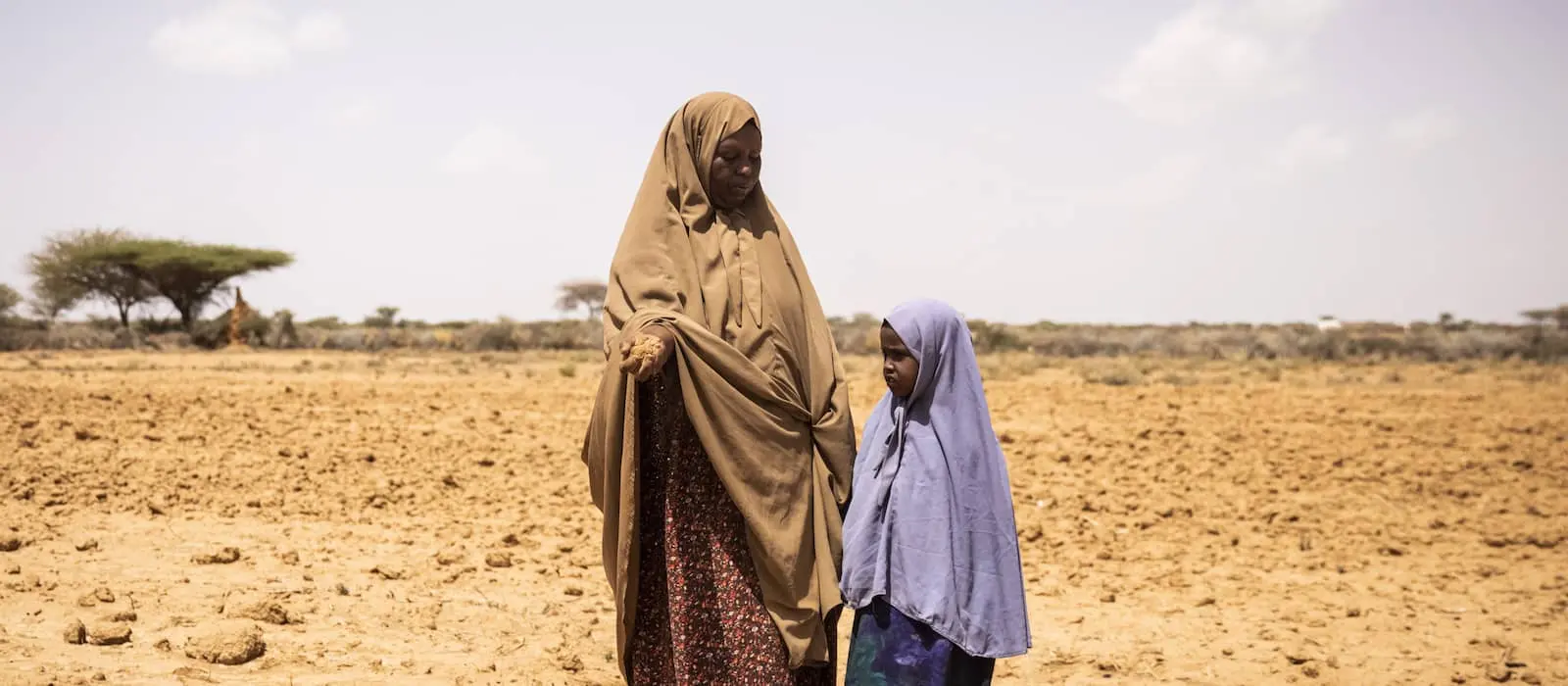 Cibaado Geedi Cali age 40 with her daughter Foosiya age 5 inspects her field in Qaloocato in Odweine.