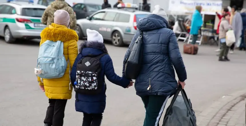 People make their way into Poland, having just crossed the frontier from Ukraine.