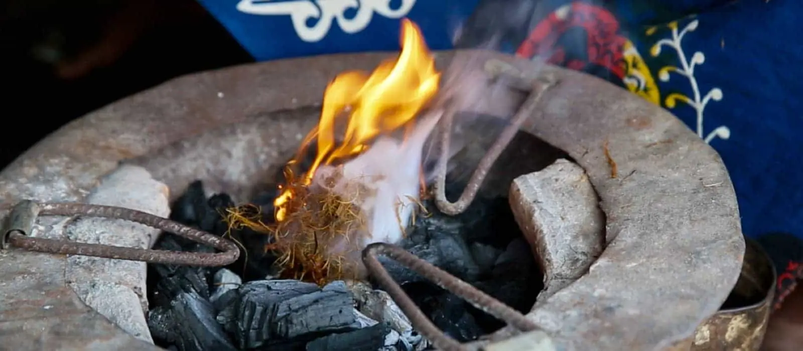 Closeup of the top of a hand made eco stove, with flaming charcoal