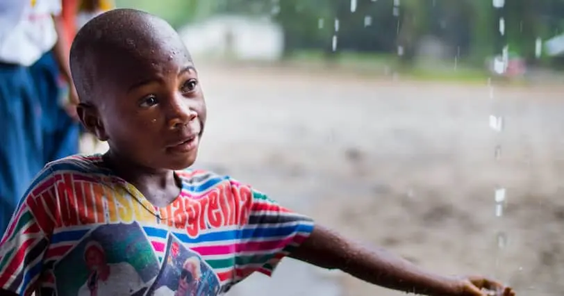 John Karyou catches rainwater during the rainy season in Liberia.