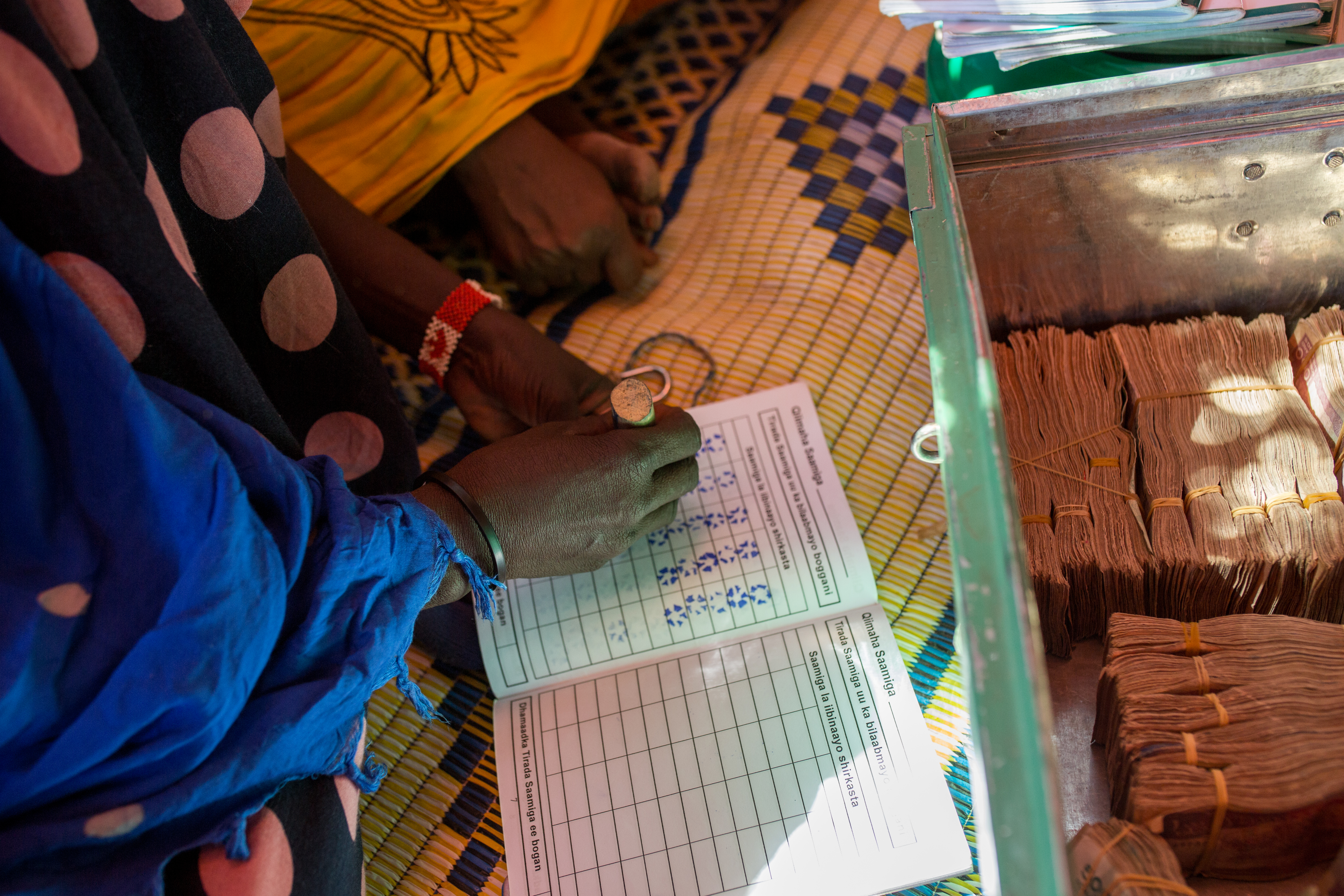 Graduation participant counting money at community group.