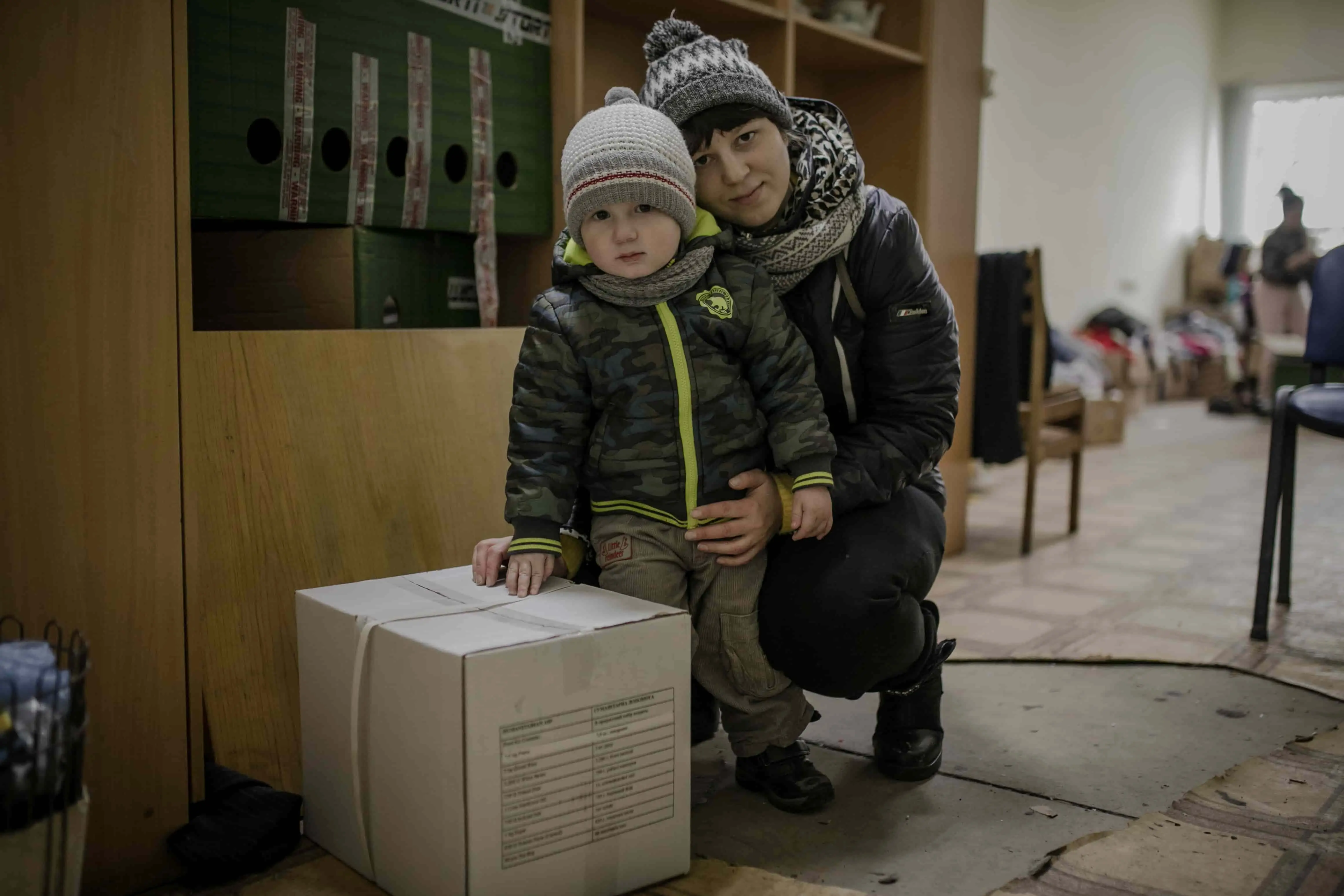 Darina* and her young son, Petro* with their food kit in Ukraine. (Photo: Simona Supino/Concern Worldwide)