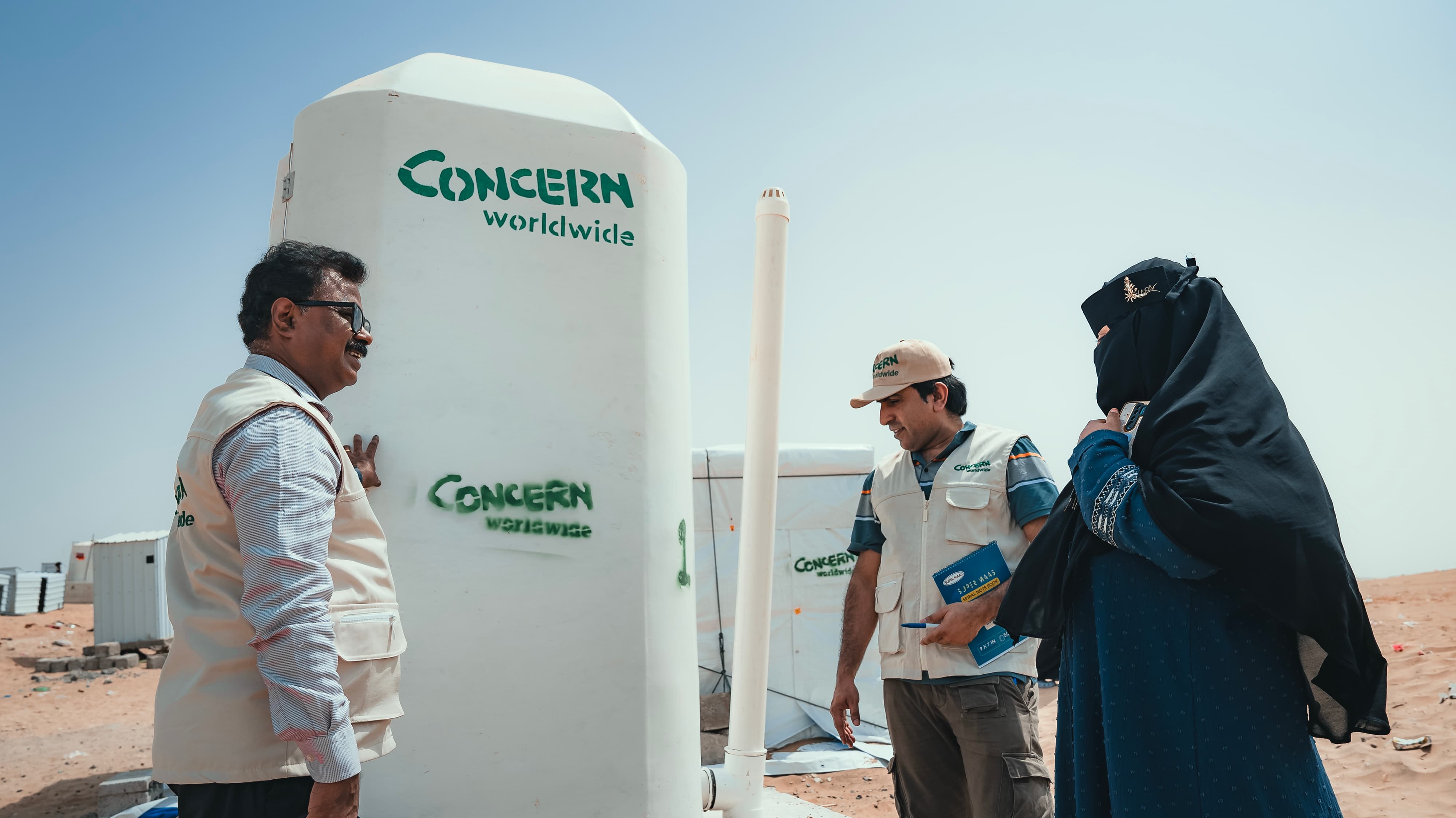 Concern Yemen Country Director Victor Moses, Programme Director Abdul Ghaffar and the Concern team distribute shelter materials, water and sanitation support to people affected by the sandstorm that struck Al Anad IDP Camp, Tuban District. (Photo: Ammar Khalaf/Concern Worldwide)