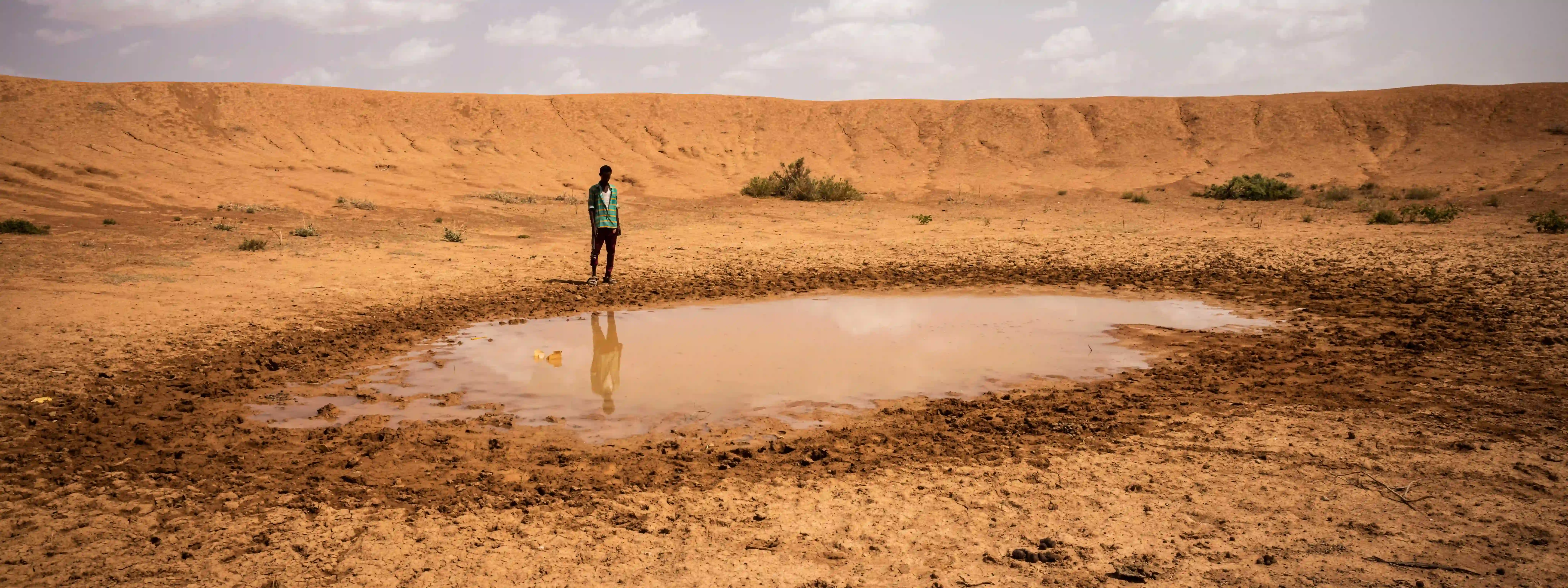 Man by shrinking waterhole